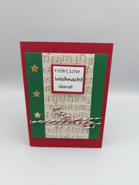 Handgemachte Weihnachtskarte mit Musikstreifen und Sternen – „Fröhliche Weihnacht überall“